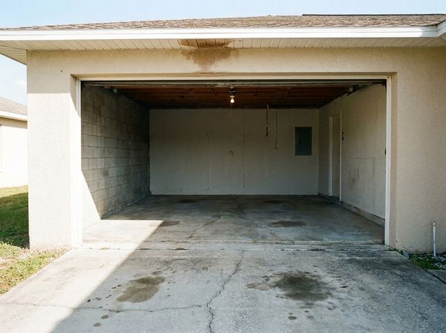 The same garage completely empty, with the concrete floor swept