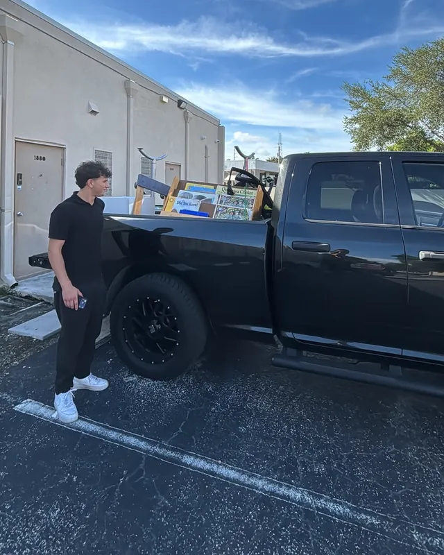 A crew member standing beside the loaded pickup after clearing an office