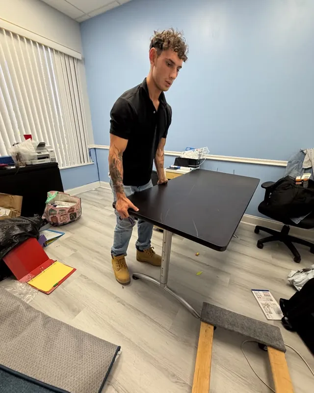 Carrying a desk out of an office during a commercial cleanout